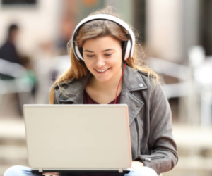 student on a computer with headphones